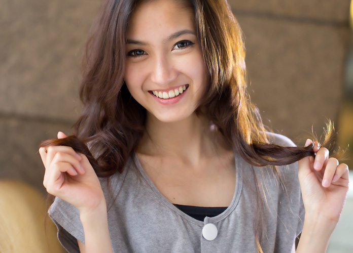 young asain woman with curly hair smiling ready for kisses